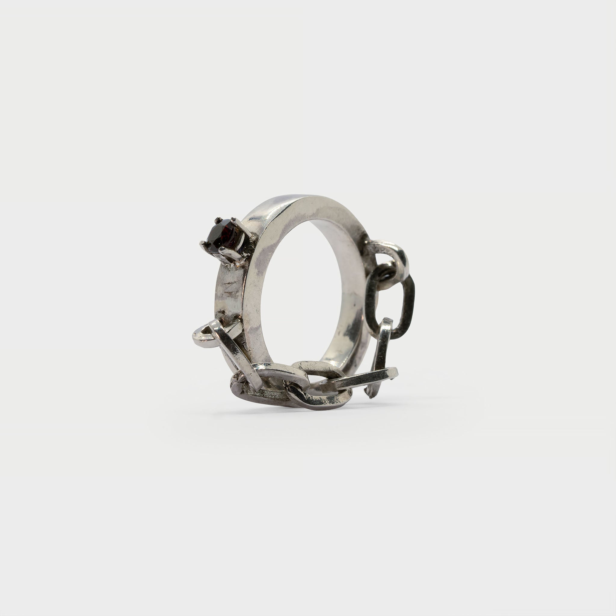 A found silver ring with a silver chain and a garnet.