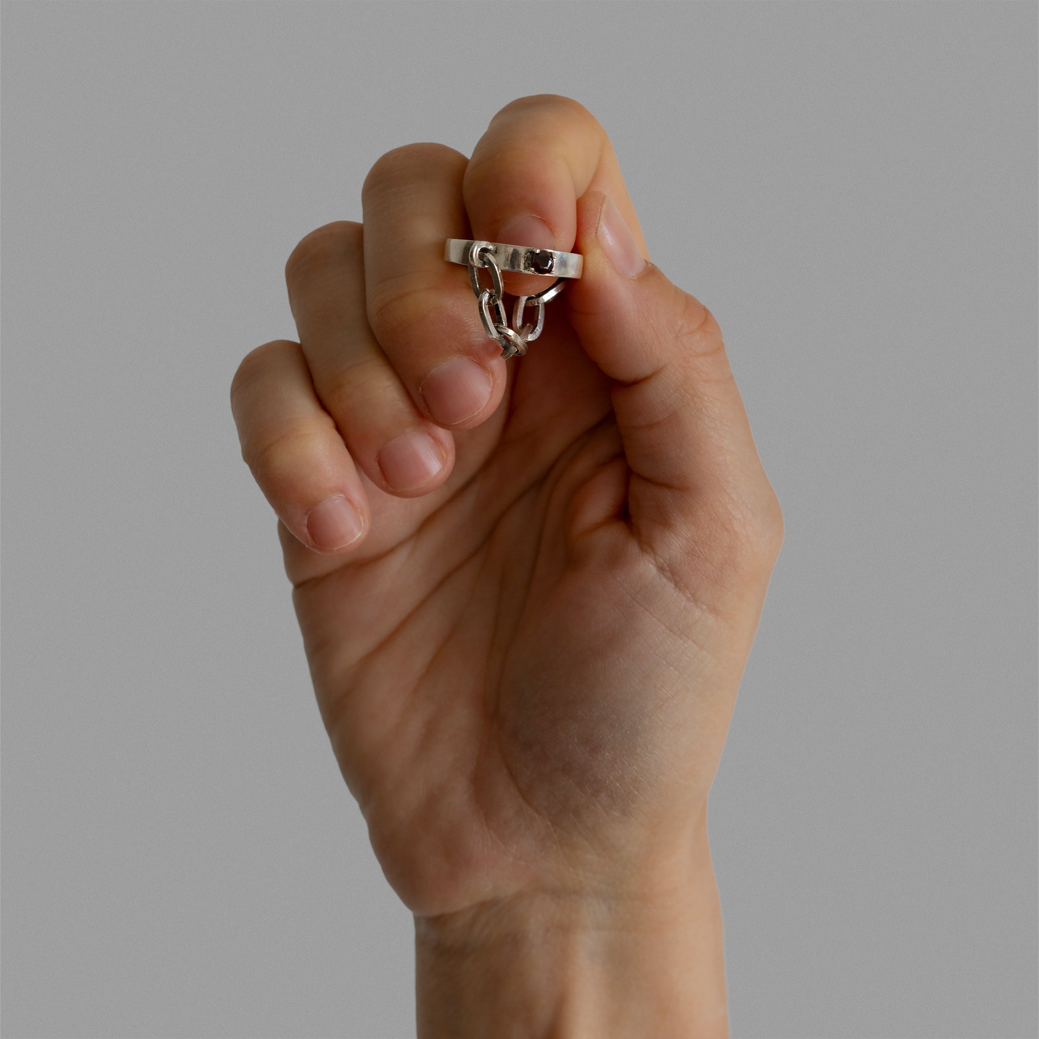 A found silver ring with a silver chain and a garnet.