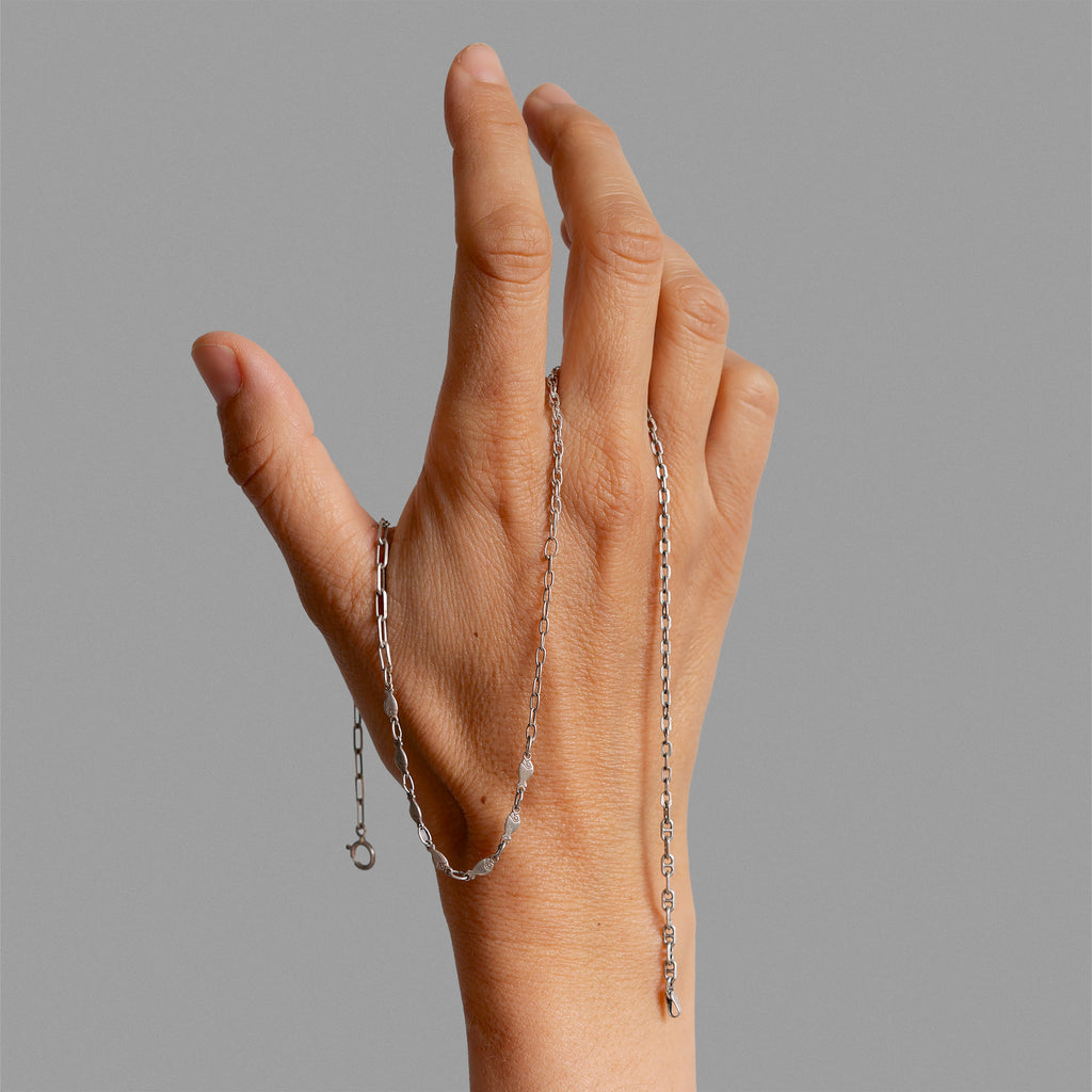 Broken chain pieces with found medal and sapphire.
