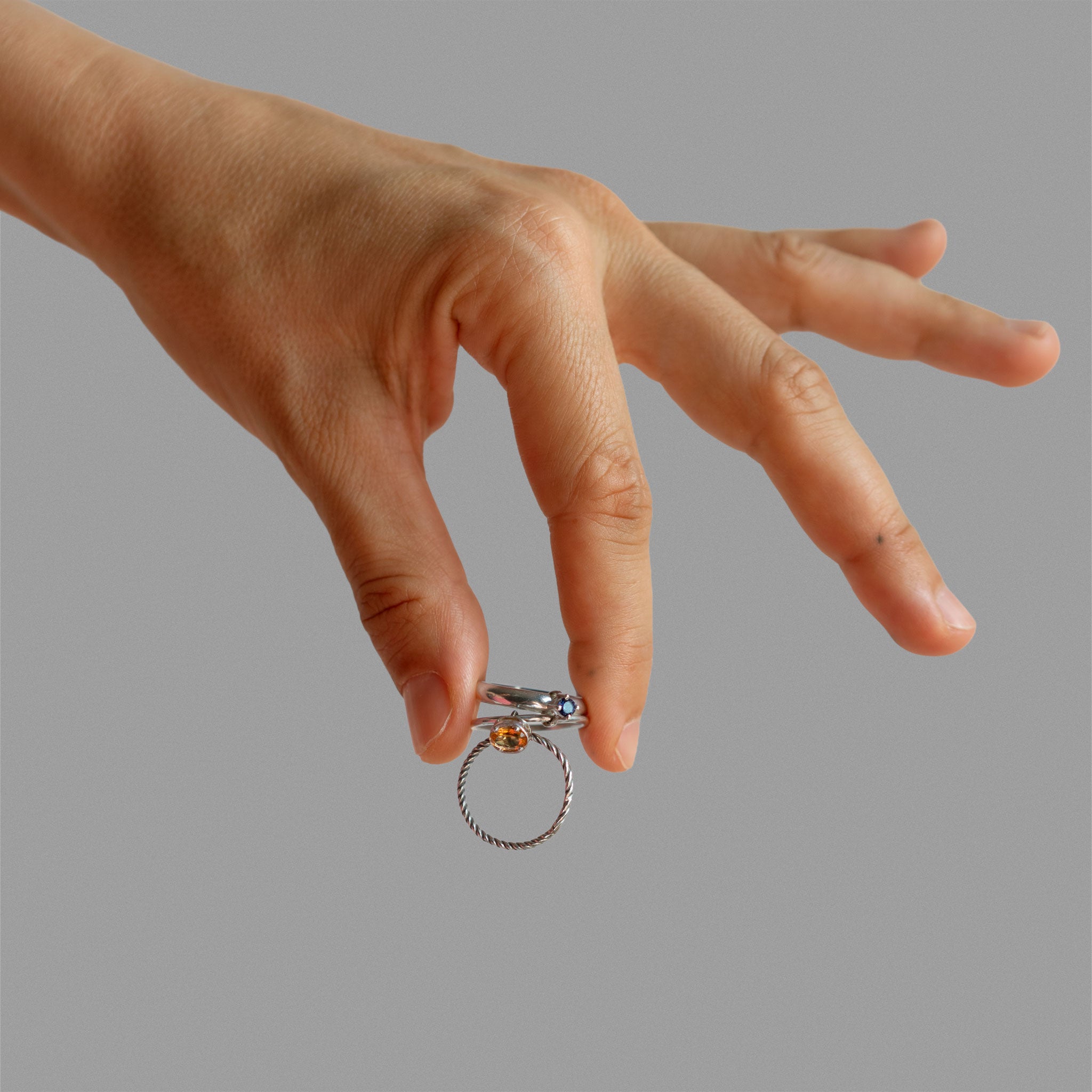 Three  found silver rings joined by bezel-set stones