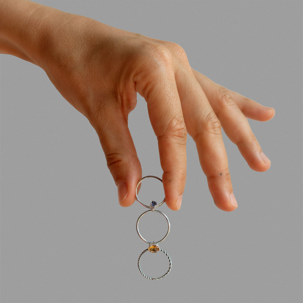 Three  found silver rings joined by bezel-set stones